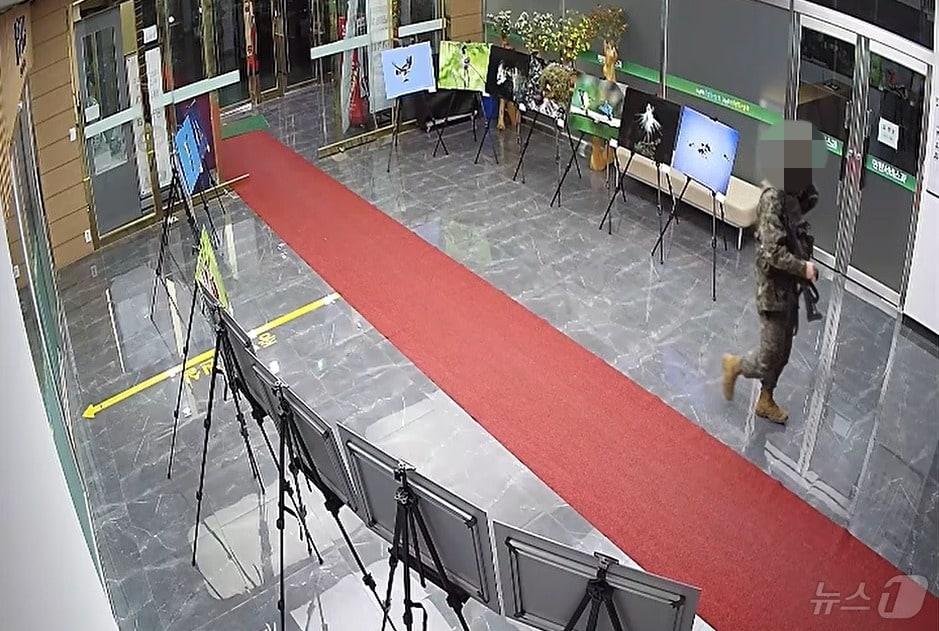 본문 이미지 - 비상계엄이 선포됐던 지난 4일 오전 0시 10분쯤 3군단 예하 육군 제21보병사단의 한 군인이 총을 소지 한 채 양구군청 내부로 이동하고 있다.(허영 국회의원실 제공)