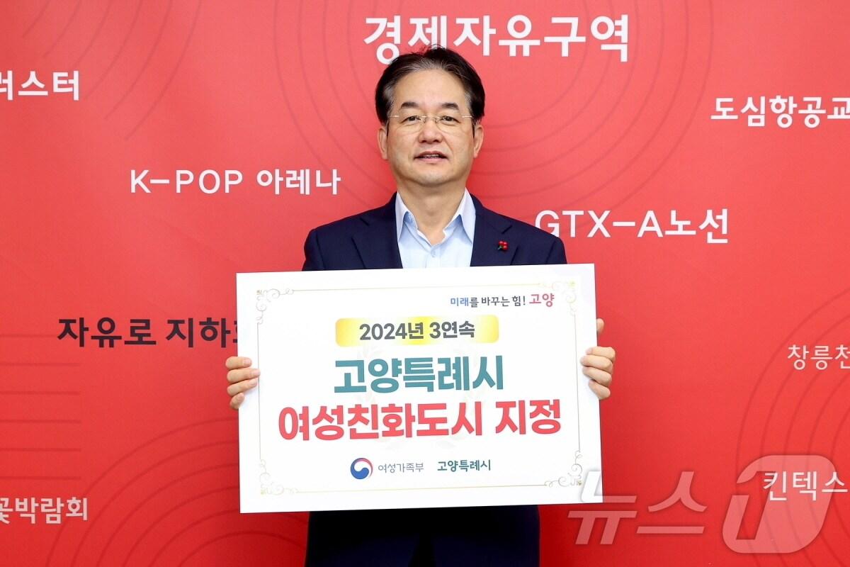 본문 이미지 - 이동환 고양시장이 여성친화도시 지정 플래카드를 들고 기념촬영을 하고 있다. (고양시 제공)