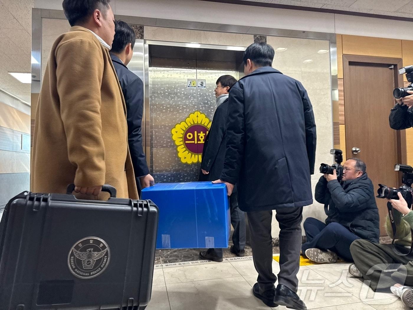 본문 이미지 - 인천경찰청 반부패경제범죄수사대는 23일 인천시의회 교육위원회에서 '전자칠판' 납품 사업 관련 뇌물수수 혐의를 받는 조현영 인천시의원의 사무실을 압수수색한 뒤 관련 자료를 상자에 담아 나오고 있다. 2024.12.23/뉴스1 ⓒ News1 박소영 기자