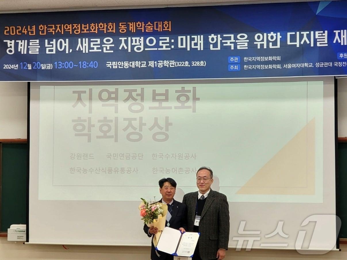 본문 이미지 - 김영호&#40;사진 왼쪽&#41; 강원랜드 기획조정실장이 최근 안동대학교에서 열린 ‘K-공공디지털혁신 대상’에서 한국지역정보화학회장상을 수상한 뒤 기념촬영을 하고 있다.&#40;강원랜드 제공&#41;