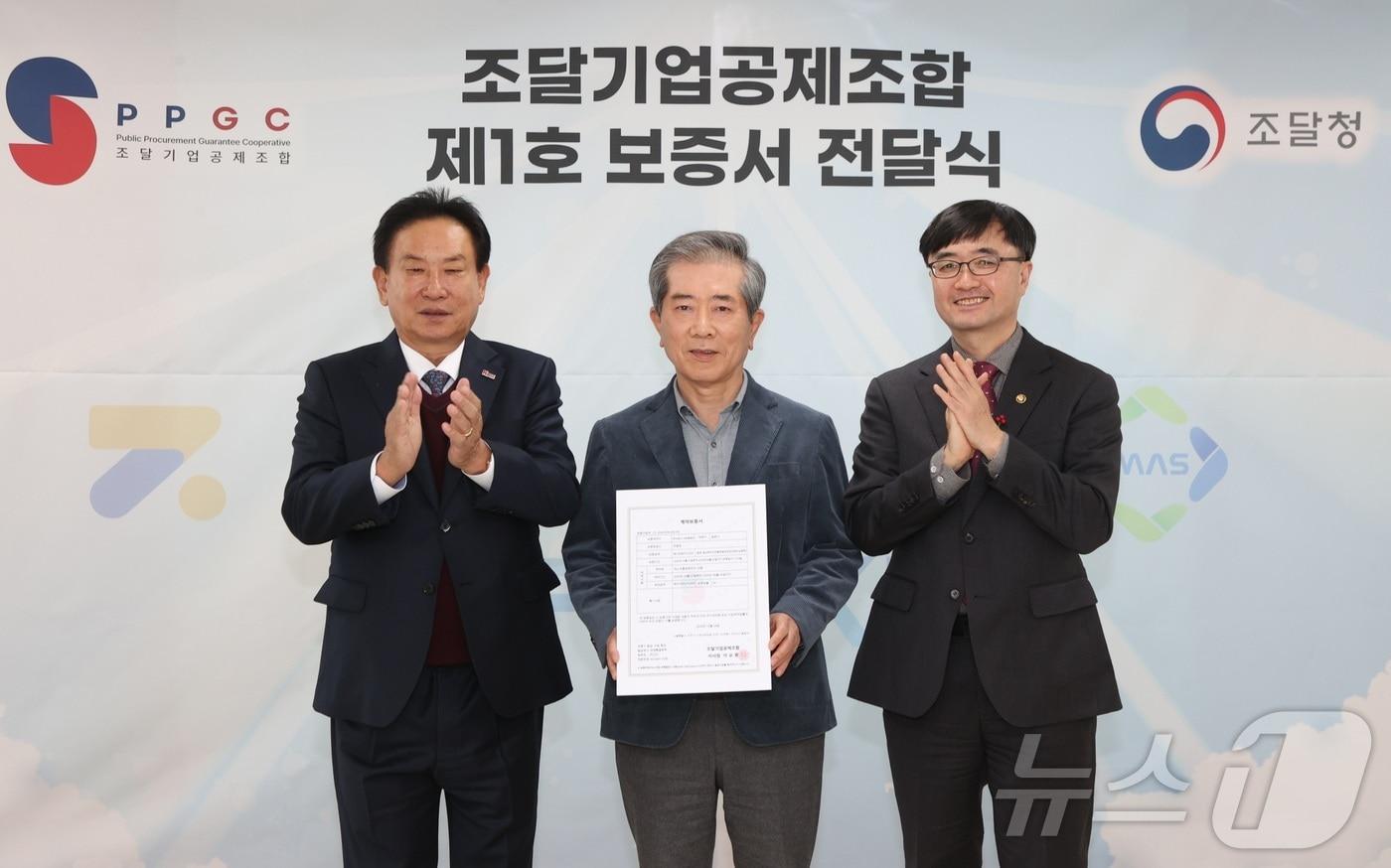 본문 이미지 - 임기근 조달청장(맨 오른쪽)이 24일 서울 조달기업공제조합 본사에서 공제조합 제1호 보증서를 받은 조달기업 관계자와 함께 기념촬영을 하고 있다. (조달청 제공)/뉴스1