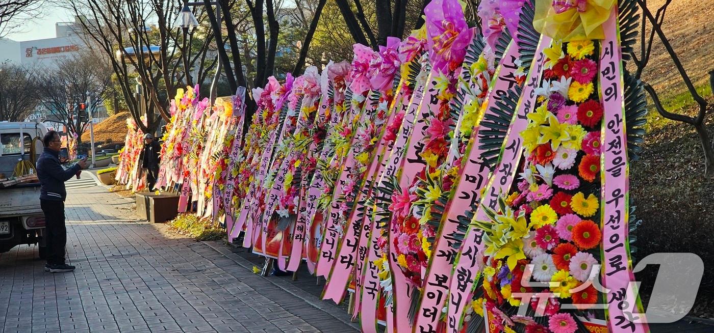 본문 이미지 - 경북 구미시가 이승환 콘서트 대관을 취소하자 24일 대관 취소를 지지하는 100여개의 격려 화환이 구미시청에 배달돼 정문앞에 늘어서 있다. 전국에서 배송된 화환에는 '정치 연예인 이승환 콘서트 취소결정을 환영한다', '정치선동 이승환 콘서트 철회를 지지한다'. '보수의 심장 구미시장 최고' 라는 문구가 적혀있다. 2024.12.24/뉴스1 ⓒ News1 정우용 기자