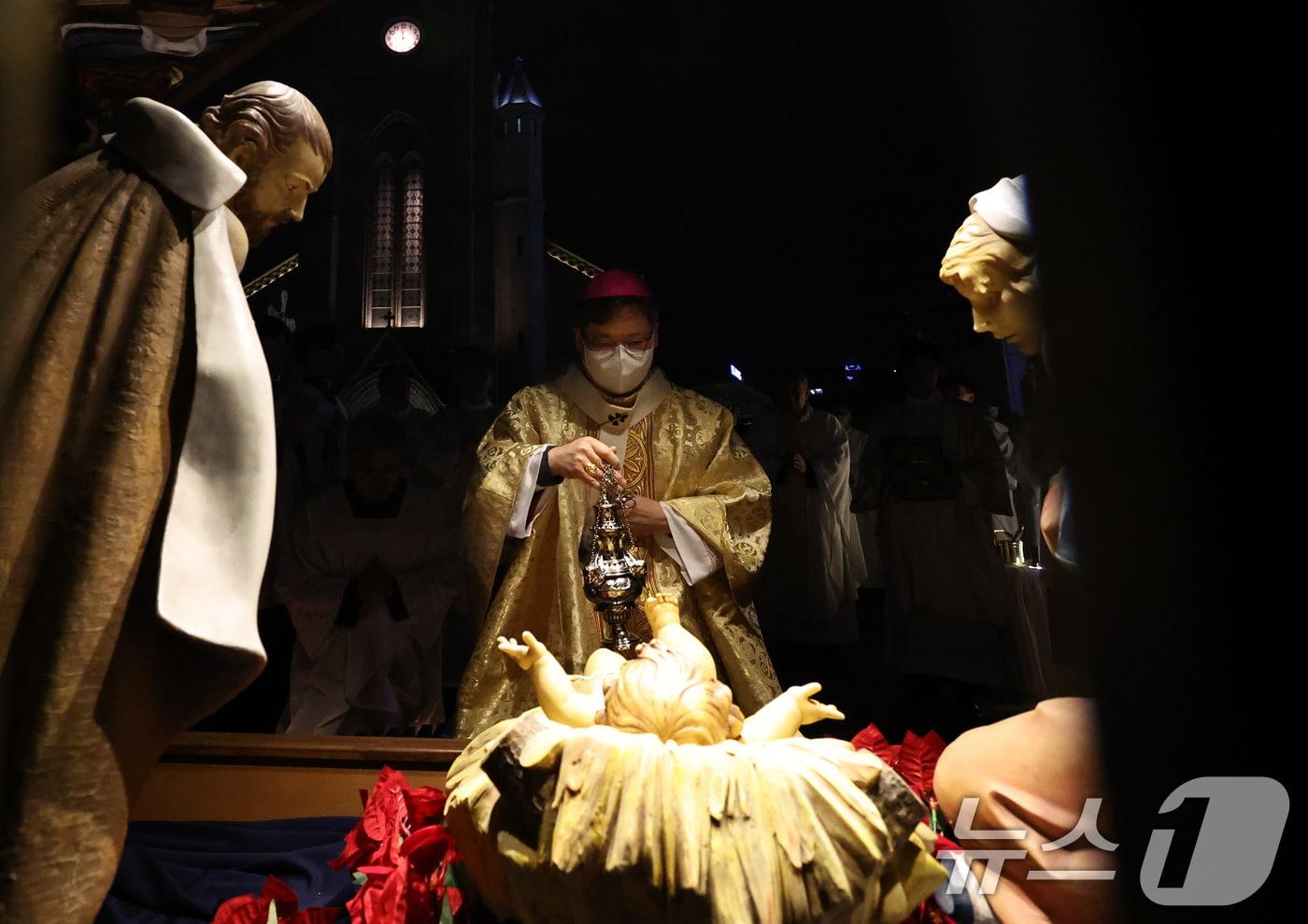 천주교 서울대교구장 정순택 대주교가 25일 새벽 서울 중구 명동대성당 앞마당에서 아기 예수를 말 구유에 안치하는 '구유 예절' 의식을 행하고 있다. 2024.12.25/뉴스1 ⓒ News1 구윤성 기자