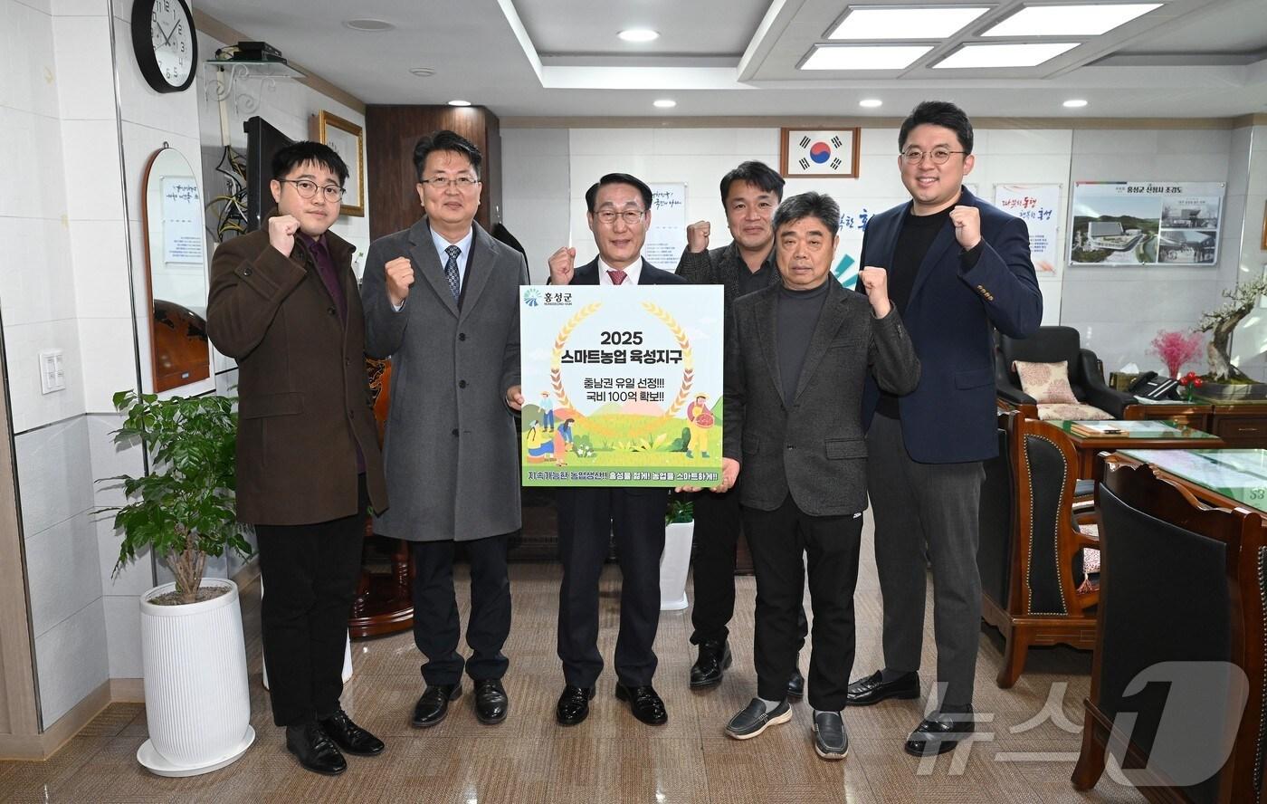 본문 이미지 - 26일 이용록 홍성군수(왼쪽 세번째)와 직원들이 ‘스마트농업 육성지구’ 선정 기념촬영을 하고 있다.(홍성군 제공) /뉴스1