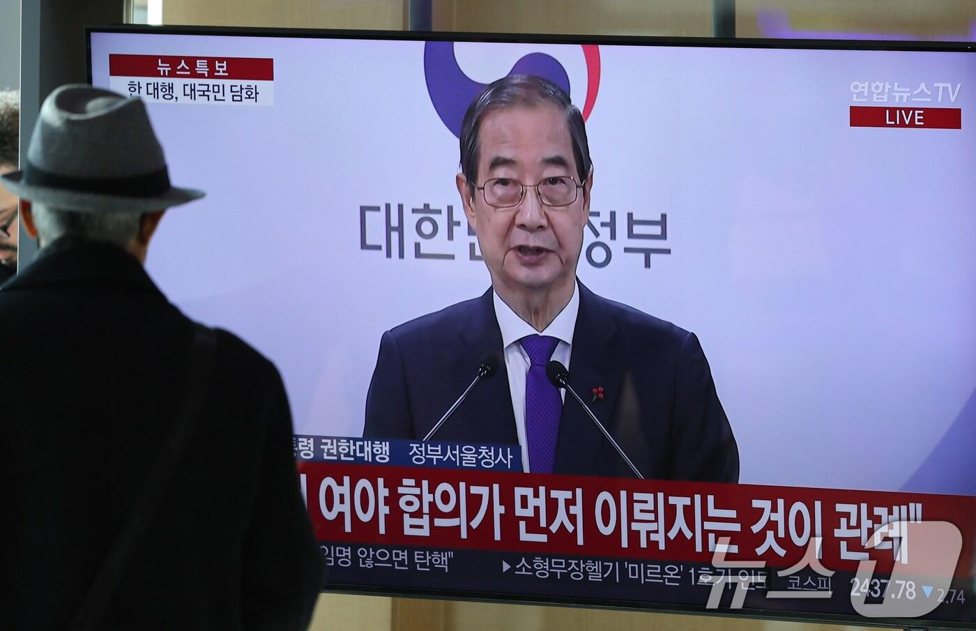 본문 이미지 - 시민들이 26일 서울역 대합실에서 한덕수 대통령 권한대행 국무총리의 대국민 담화를 시청하고 있다. 한 권한대행 이날 대국민 담화에서 "여야가 합의해 안을 제출하실 때까지 저는 헌법재판관 임명을 보류하겠다＂고 밝혔다. 2024.12.26/뉴스1 ⓒ News1 신웅수 기자