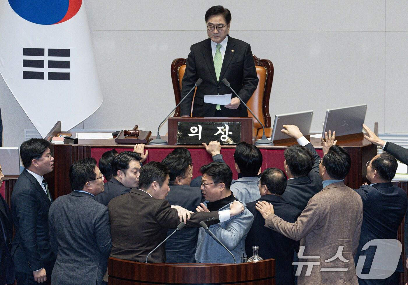 본문 이미지 - 강명구 국민의힘 의원(오른쪽)과 김용만 더불어민주당 의원이 27일 오후 서울 여의도 국회 본회의장에서 열린 제420회 국회(임시회) 제2차 본회의에서 한덕수 대통령 권한대행 국무총리 탄핵소추안 탄핵 의결 정족수 과반 151명이라고 밝히자 다툼을 벌이고 있다. 2024.12.27/뉴스1 ⓒ News1 이재명 기자