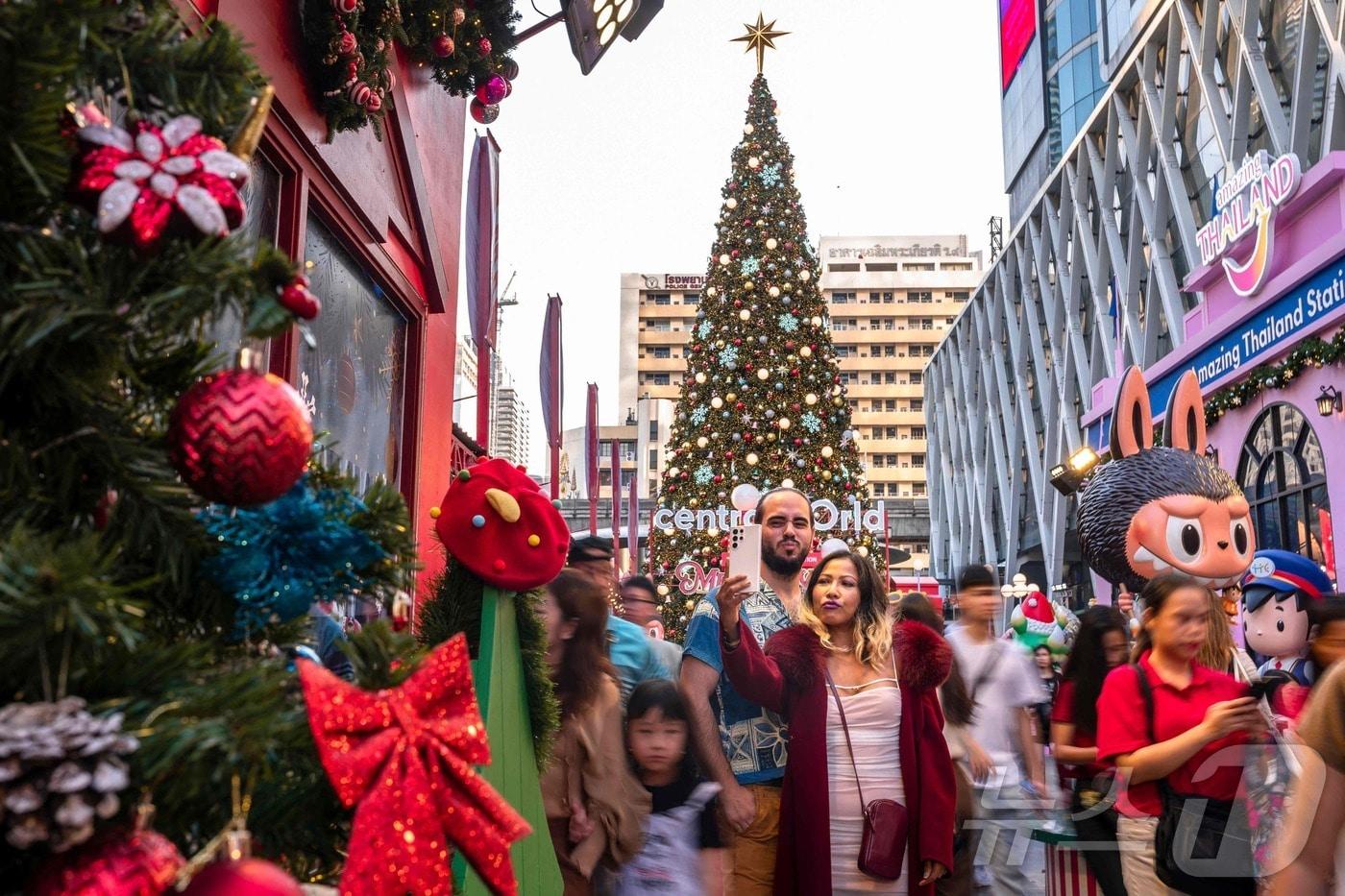 크리스마스 이브인 24일 방콕 센트럴월드몰에서 사람들이 사진을 촬영하고 있다. 2024.12.24 ⓒ AFP=뉴스1