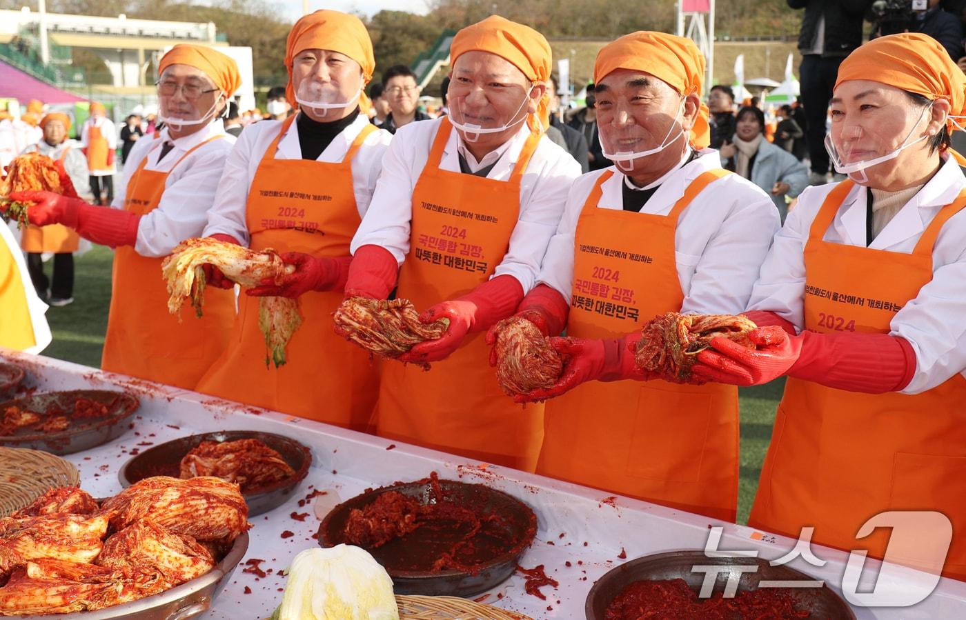 본문 이미지 - 3일 울산시 남구 문수야구장에서 '2024 국민통합 김장, 따뜻한 대한민국' 행사가 열린 가운데 이상민 행정안전부 장관(가운데)을 비롯한 참석자들이 김치를 들어보이고 있다. . 2024.12.3/뉴스1 ⓒ News1 조민주 기자