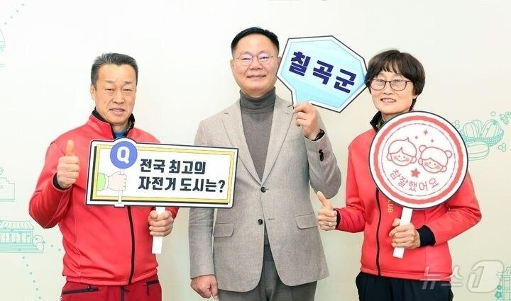 본문 이미지 - 김재욱(가운데) 칠곡군수가 김태경(왼쪽) 칠곡군 자전거연맹회과 사진을 찍고 있다. (칠곡군 제공) 2024.12.30/뉴스1