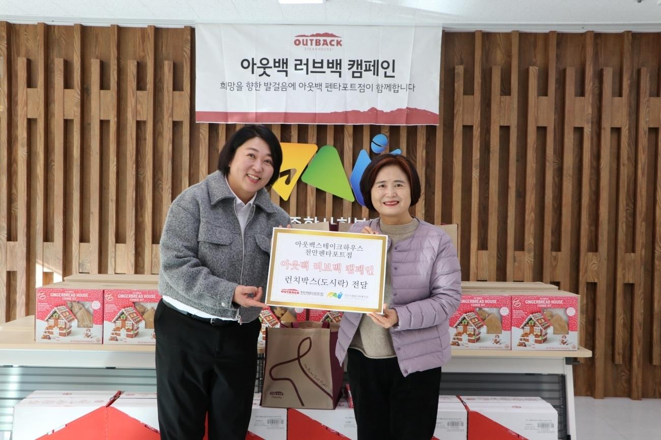 본문 이미지 - 박금석 아웃백 천안펜타포트점 점주(왼쪽)과 문명희 천안시종합사회복지관 관장이 기념 사진을 촬영하고 있다.(다이닝브랜즈그룹 제공)
