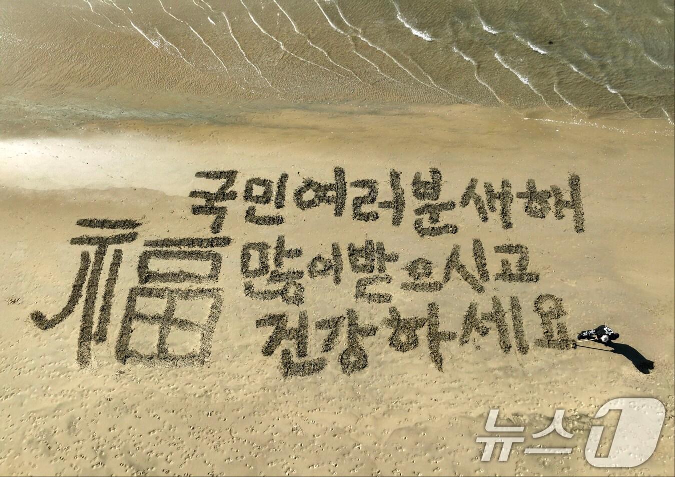 본문 이미지 - 독도 서예가 김동욱 씨가 30일 경북 포항시 송도해수욕장 백사장에서 '2025 을사년 새해 퍼포먼스'를 하고 있다. 2024.12.30/뉴스1 ⓒ News1 최창호 기자