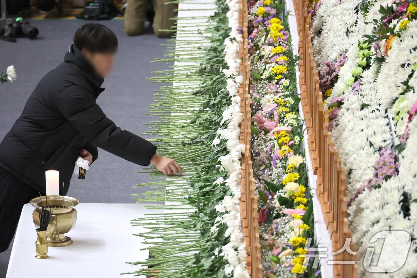 무안 제주항공 참사 발생 다음날인 30일 낮 전남 무안군 무안종합스포츠파크에 마련된 희생자 합동분향소에 방문한 조문객들이 헌화하고 있다. 2024.12.30 공동취재사진 ⓒ News1 김민지 기자