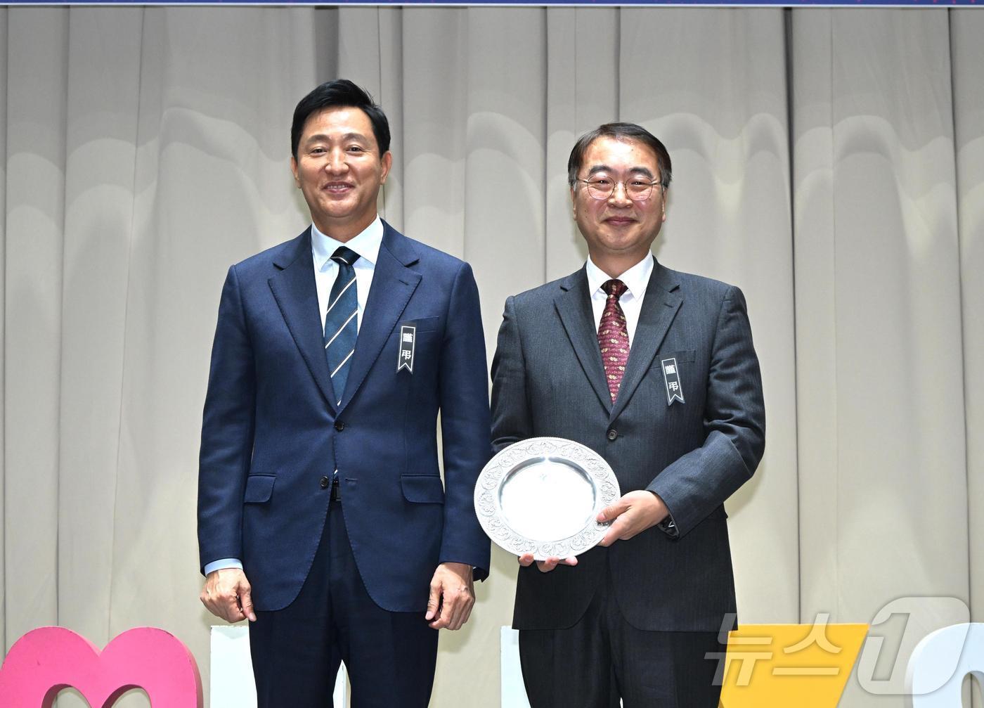 본문 이미지 - 오세훈 서울시장이 30일 김상한 서울시 행정1부시장 이임식에서 공로패를 전달한 후 김 부시장과 기념 촬영하고 있다.(서울시 제공)