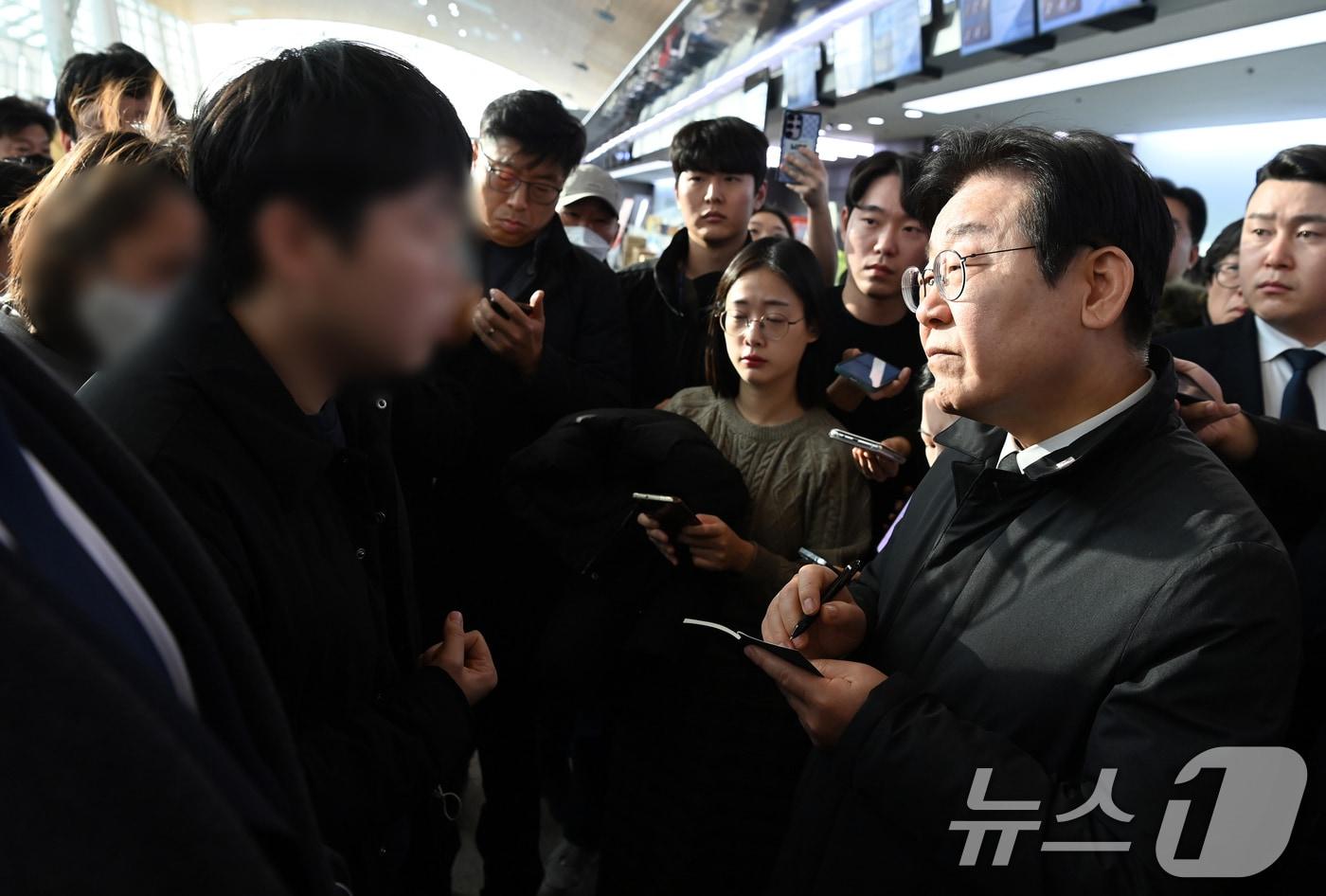 이재명 더불어민주당 대표가 31일 오전 전남 무안군 무안국제공항 터미널을 찾아 제주항공 여객기 사고 희생자 유가족을 위로하며 요구사항을 수첩에 적고 있다. (공동취재) 2024.12.31/뉴스1 ⓒ News1 김성진 기자