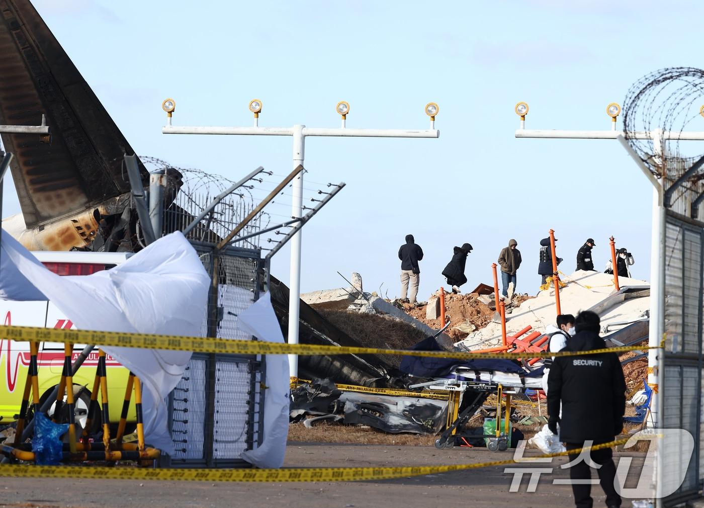 본문 이미지 - 31일 오후 전남 무안국제공항 제주항공 여객기 참사 현장에서 미국 연방항공청, 교통안전위원회, 보잉 등 한미합동조사 관계자들이 사고 여객기와 충돌로 부서진 방위각 시설&#40;로컬라이저&#41; 등을 조사하고 있다. 2024.12.31/뉴스1 ⓒ News1 김민지 기자