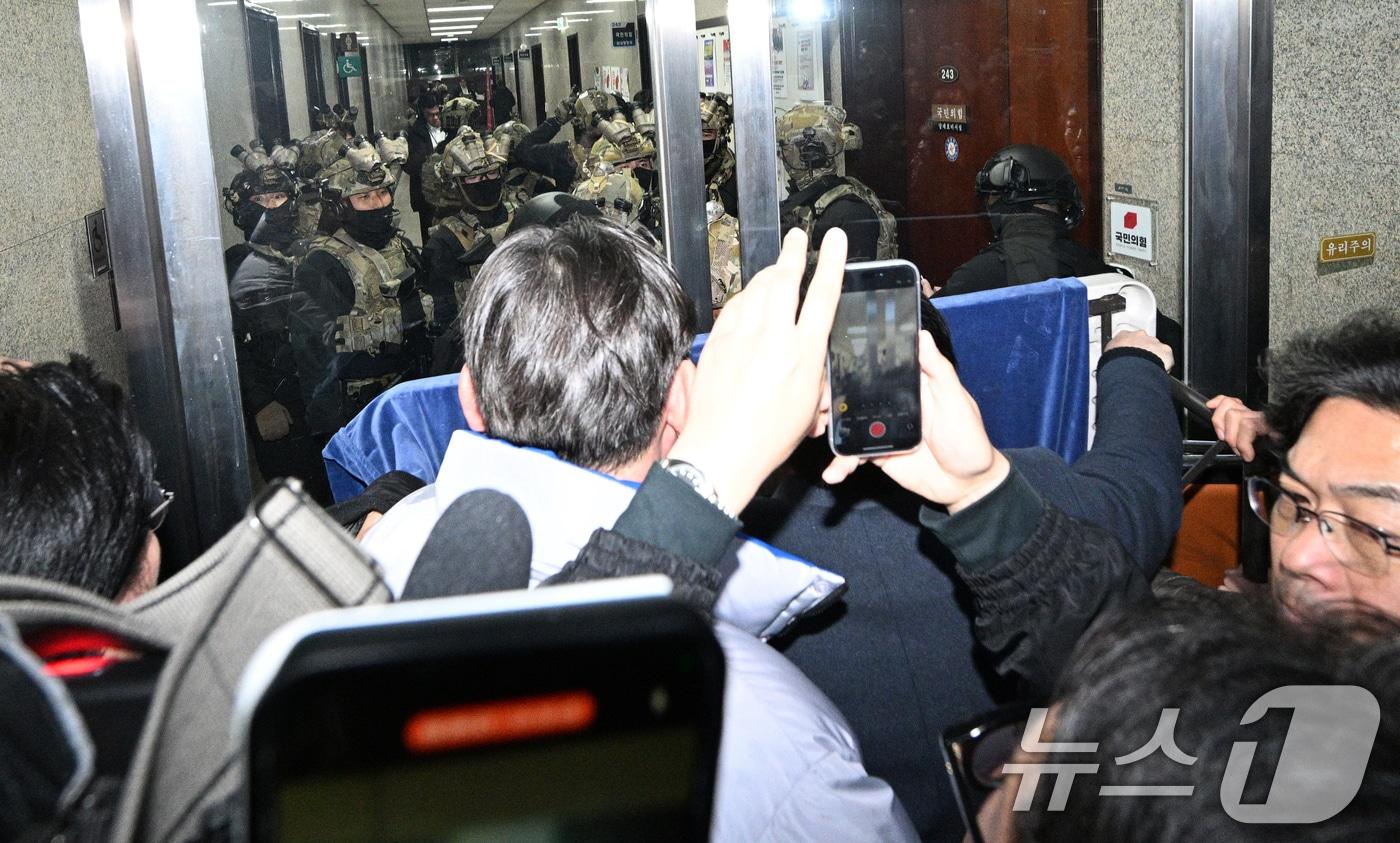 본문 이미지 - 윤석열 대통령이 전격적으로 비상계엄령을 선포한 4일 새벽 계엄군들이 국회 본청 진입을 시도하자 국회 보좌진 등 직원들이 대치하고 있다. 2024.12.4 ⓒ 뉴스1 김민지 기자