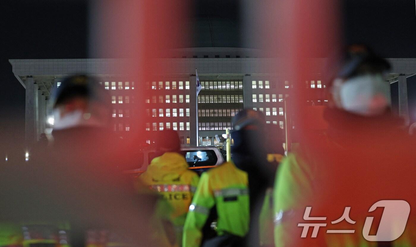 본문 이미지 - 윤석열 대통령의 비상계엄 해제 요구 결의안이 국회 본회의에서 통과된 4일 새벽 서울 여의도 국회 정문을 경찰이 통제하고 있다. 여야는 이날 본회의에서 재석 190명 중 찬성 190명으로 비상계엄 해제 요구 결의안을 가결 처리했다. 이에 따라 계엄령 선포는 무효가 됐다고 국회의장실은 설명했다. 2024.12.4/뉴스1 ⓒ News1 장수영 기자