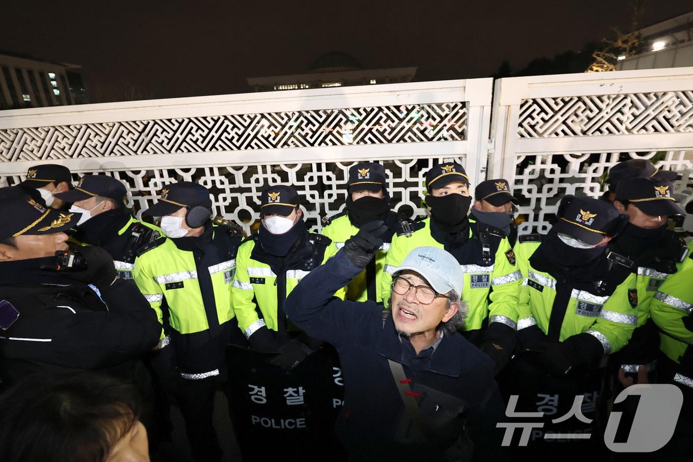비상계엄이 선포된 지난해 12월 3일 밤 서울 여의도 국회 앞에서 한 시민이 &#39;비상계엄 해제&#39;를 촉구하며 소리치고 있다. 2024.12.4/뉴스1 ⓒ News1 구윤성 기자