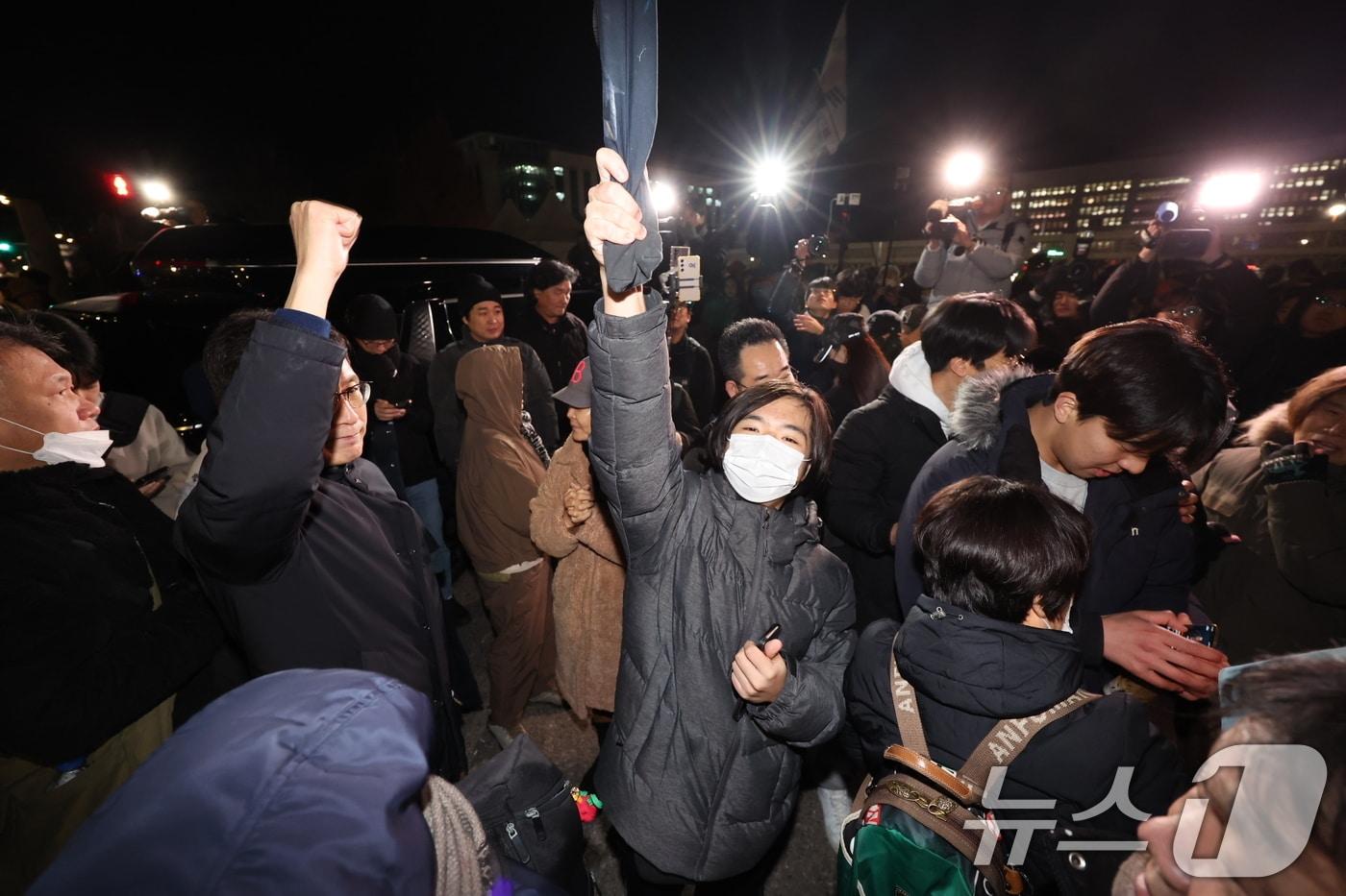 비상계엄 해제 요구 결의안이 국회 본회의에서 통과된 4일 새벽 서울 여의도 국회 인근에서 시민들이 윤석열 대통령의 비상계엄 해제 관련 담화를 지켜보며 환호하고 있다. 2024.12.4/뉴스1 ⓒ News1 이재명 기자