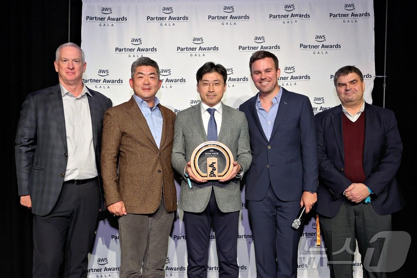 이주완 메가존클라우드 대표(가운데), 황인철 메가존클라우드 AWS 사업부문 대표(중앙 왼쪽), 크리스토퍼 설리번 AWS 채널 얼라이언스 부사장(왼쪽), 크리스 케이시 AWS APJ 파트너 디렉터(중앙 오른쪽), 안토니오 알론소 로페즈 AWS EMEA 파트너 디렉터(오른쪽)가 기념사진을 찍고 있다.(메가존클라우드 제공)
