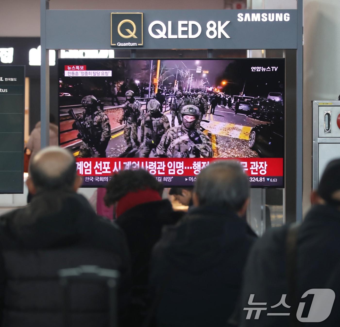 본문 이미지 - 비상 계엄이 해제된 4일 부산 동구 부산역 대합실에서 시민들이 윤석열 대통령의 비상 계엄 선포와 관련한 뉴스를 보고 있다. 2024.12.4/뉴스1 ⓒ News1 윤일지 기자