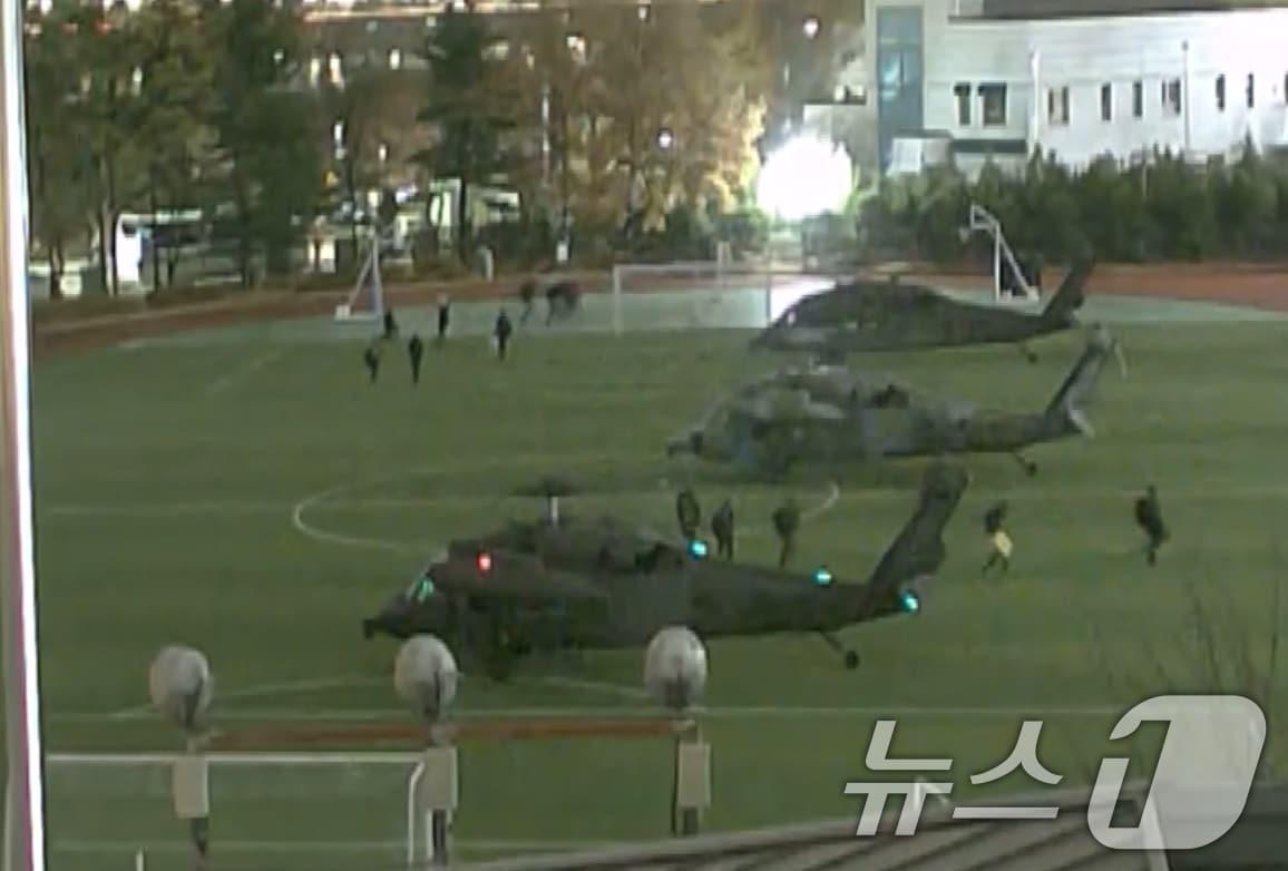 본문 이미지 - 국회사무처가 2024년 12월 4일 공개한 계엄군의 국회 본관 진입 과정이 담긴 CCTV.  김민기 국회사무총장은 국방부가 헬기로 24차례에 걸쳐 무장한 계엄군 230여 명을 국회 경내로 진입시켰다며 0시 40분에는 계엄군 50여 명을 추가로 국회 외곽 담장을 넘어 진입시켰다고 전했다. 사진은 헬기를 타고 국회 내에 진입한 계엄군 모습. (국회사무처 제공) 2024.12.4/뉴스1