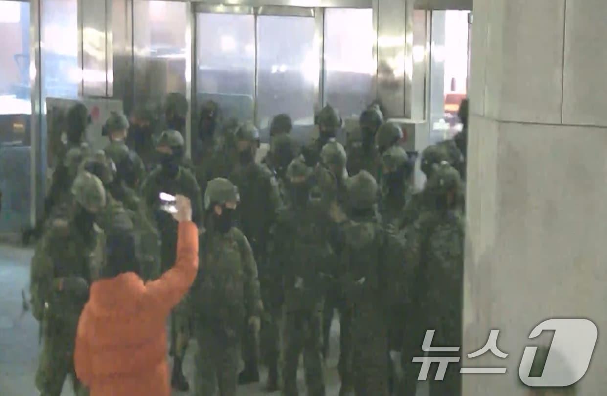 본문 이미지 - 국회사무처가 계엄군의 국회 본관 진입 과정이 담긴 CCTV를 4일 공개했다. 김민기 국회사무총장은 국방부가 헬기로 24차례에 걸쳐 무장한 계엄군 230여 명을 국회 경내로 진입시켰다며 0시 40분에는 계엄군 50여 명을 추가로 국회 외곽 담장을 넘어 진입시켰다고 전했다. 사진은 국회 본관 진입을 시도하는 계엄군 모습. &#40;국회사무처 제공&#41; 2024.12.4/뉴스1