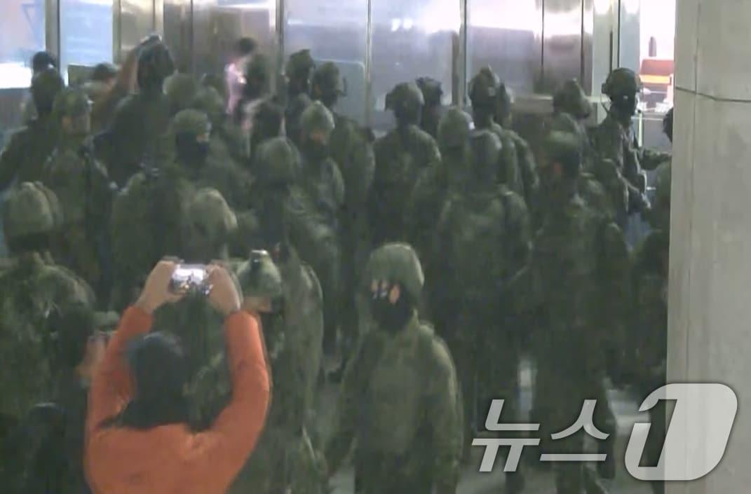 본문 이미지 - 국회사무처가 계엄군의 국회 본관 진입 과정이 담긴 CCTV를 4일 공개했다. 김민기 국회사무총장은 국방부가 헬기로 24차례에 걸쳐 무장한 계엄군 230여 명을 국회 경내로 진입시켰다며 0시 40분에는 계엄군 50여 명을 추가로 국회 외곽 담장을 넘어 진입시켰다고 전했다. 사진은 국회 본관 진입을 시도하는 계엄군 모습. &#40;국회사무처 제공&#41; 2024.12.4/뉴스1