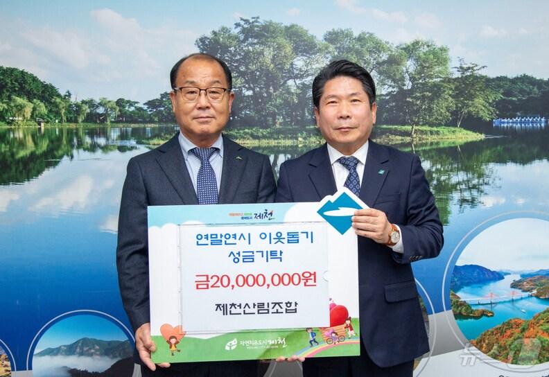 본문 이미지 - 배명구(왼쪽) 제천산림조합장이 김창규 제천시장에게 성금을 전달하고 있다.2024.12.4/뉴스1