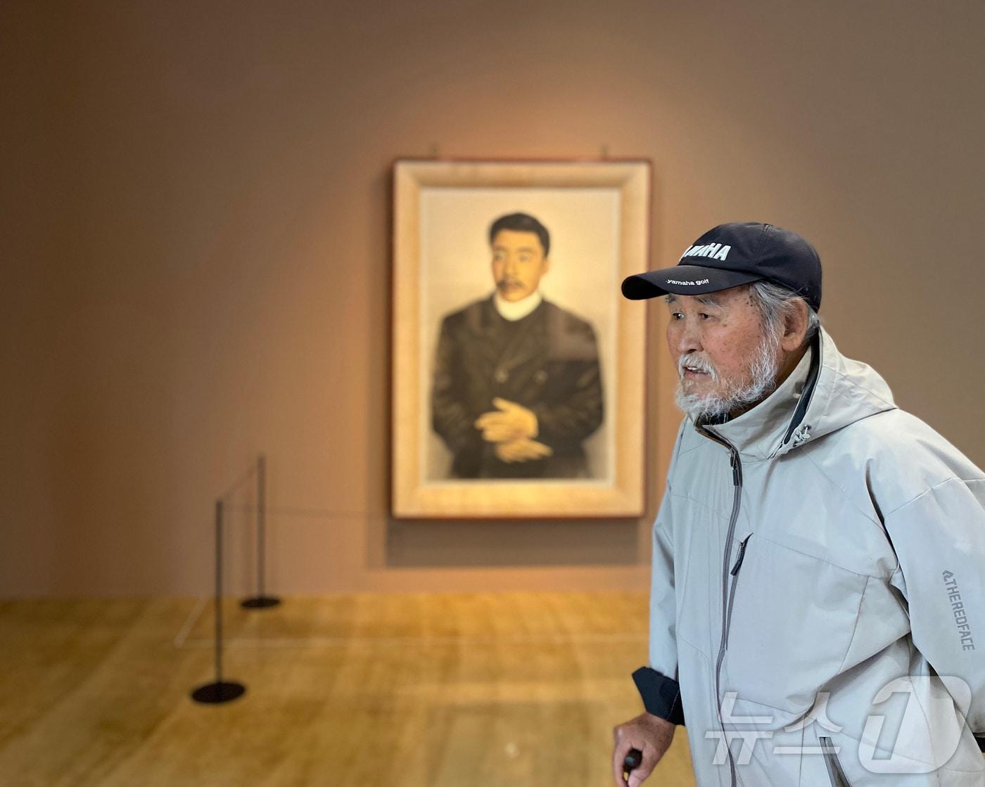 본문 이미지 - 강원 춘천 이상원미술관에서 10주년 기념전 '이상원, 50년 예술의 여정-파괴될 수 있지만, 패배하지 않는다' 전시중인 안중근의사 영정 앞 이상원 화백.(이상원미술관 제공)