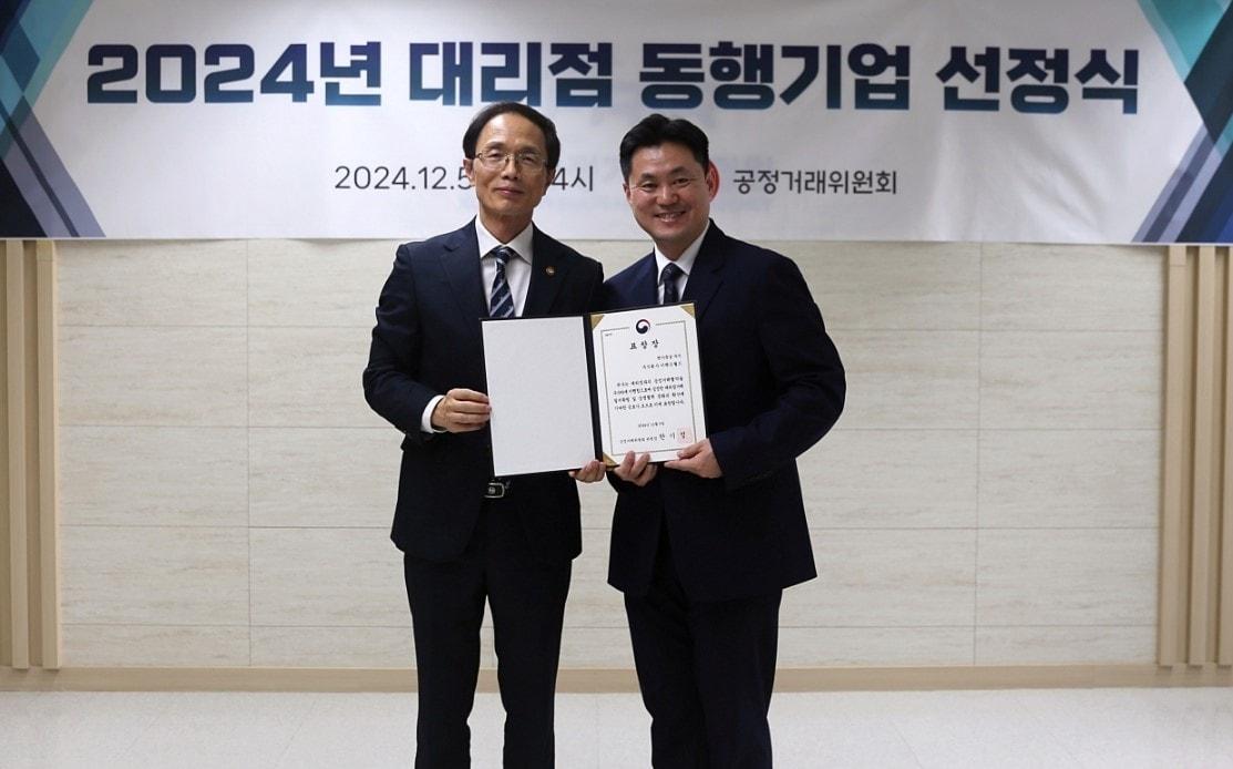 본문 이미지 - 이랜드월드가 공정거래위원회 주관 ‘대리점 동행기업’으로 4년 연속 선정돼 조홍선 공정거래위원회 부위원장&#40;사진 왼쪽&#41;과 조동주 이랜드월드 대표이사&#40;오른쪽&#41;가 기념 사진을 찍고 있다. &#40;이랜드월드 제공&#41;