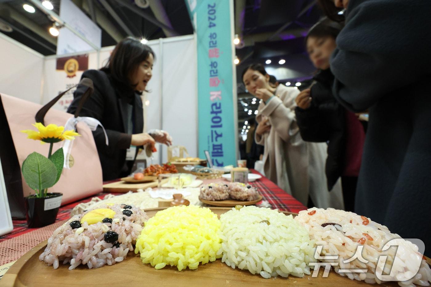 본문 이미지 - 6일 경기 고양시 킨텍스에서 열린 '2024 우리쌀·우리술 K-라이스페스타'를 찾은 관람객들이 쌀을 이용한 제품을 살펴보고 있다. 국산 쌀 소비확대를 위해 농협이 오는 8일까지 개최하는 이번 행사에는 쌀 가공식품 및 전통주 제조·판매업체 250여 개가 참여한다. 2024.12.6 ⓒ 뉴스1 신웅수 기자