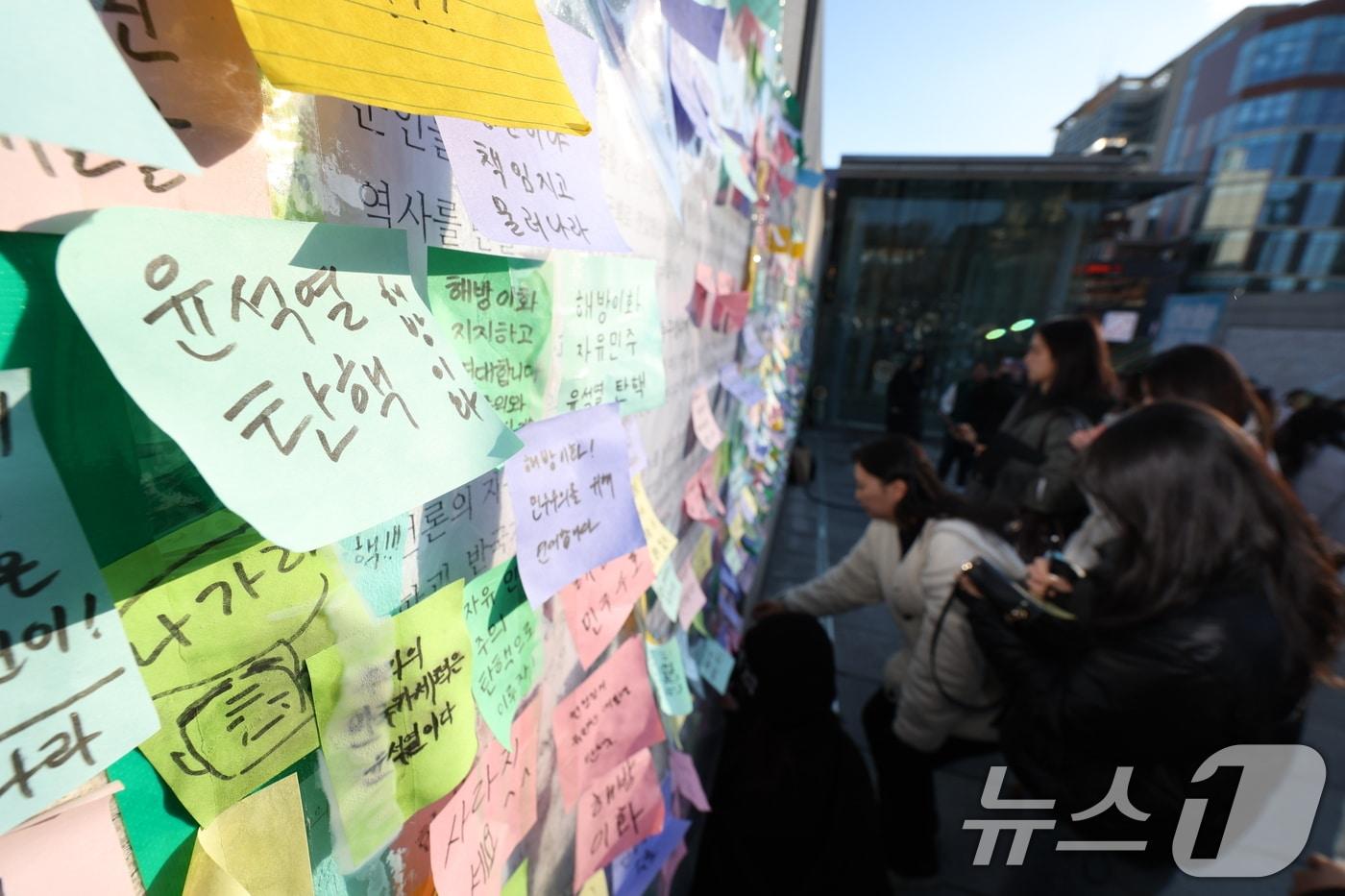 이화여대 재학생들이 6일 오후 서울 서대문구 이화여대 앞에서 윤석열 대통령의 퇴진을 촉구하는 시국 선언을 한 후 대자보에 메시지를 붙이고 있다. 2024.12.6/뉴스1 ⓒ News1 신웅수 기자
