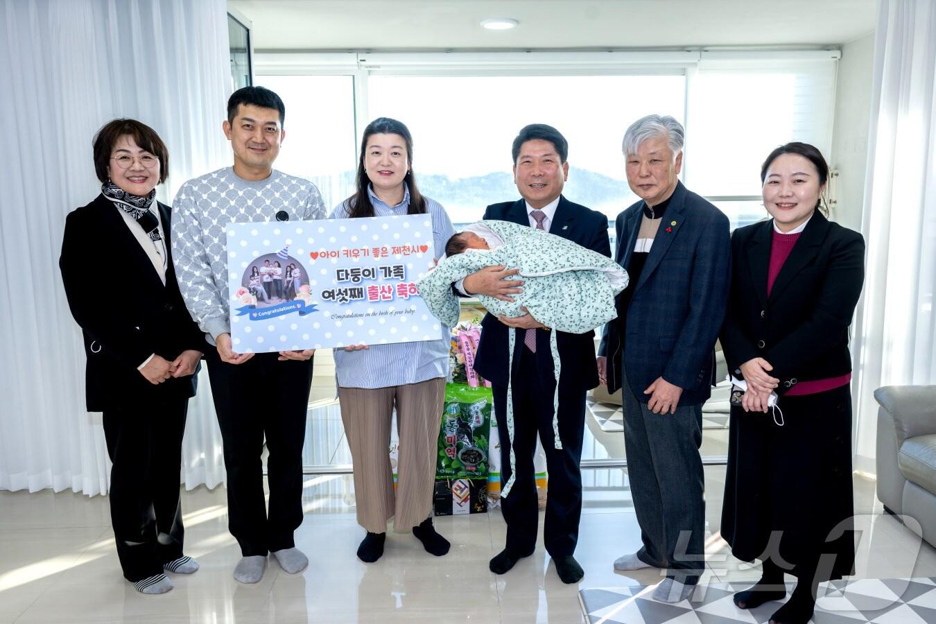 본문 이미지 - 김창규(가운데) 제천시장이 지난 6일 6남매 가정에 방문해 여섯째를 안고 기념사진을 찍고 있다.2024.12.7/뉴스1