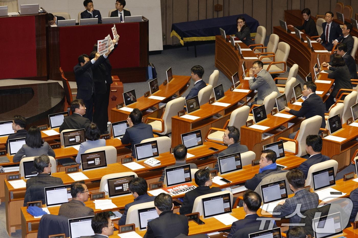 윤석열 대통령 탄핵·김건희 여사 특검법 표결을 앞둔 7일 오후 서울 여의도 국회 본회의장에서 야당 의원들이 국민의힘 의원들을 향해 탄핵안 가결을 촉구하는 피켓을 들어보이고 있다. 2024.12.7/뉴스1 ⓒ News1 안은나 기자