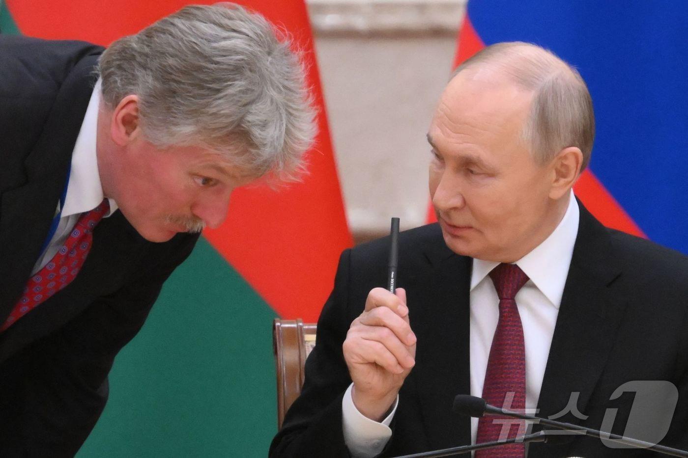 블라디미르 푸틴 러시아 대통령이 민스크 대통령 궁에서 알렉산드르 루카셴코 벨라루스 대통령과 회담 중 드미트리 페스코프 크렘린궁 대변인과 얘기를 하고 있다. 2024.12.08 ⓒ AFP=뉴스1 ⓒ News1 우동명 기자