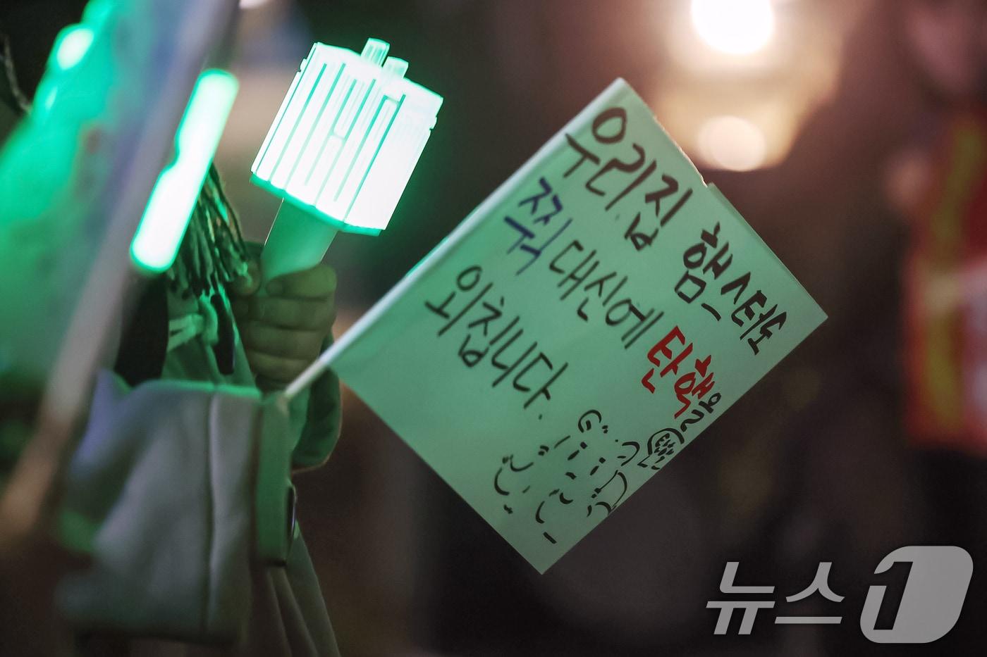 본문 이미지 - 8일 오후 서울 영등포구 여의도 국회의사당 앞에서에서 열린 촛불문화제에 참가한 한 시민이 "우리집 햄스터도 쮝 대신에 탄핵을 외칩니다"라고 적힌 깃발을 들고 있다. 2024.12.08/뉴스1 ⓒ News1 민경석 기자