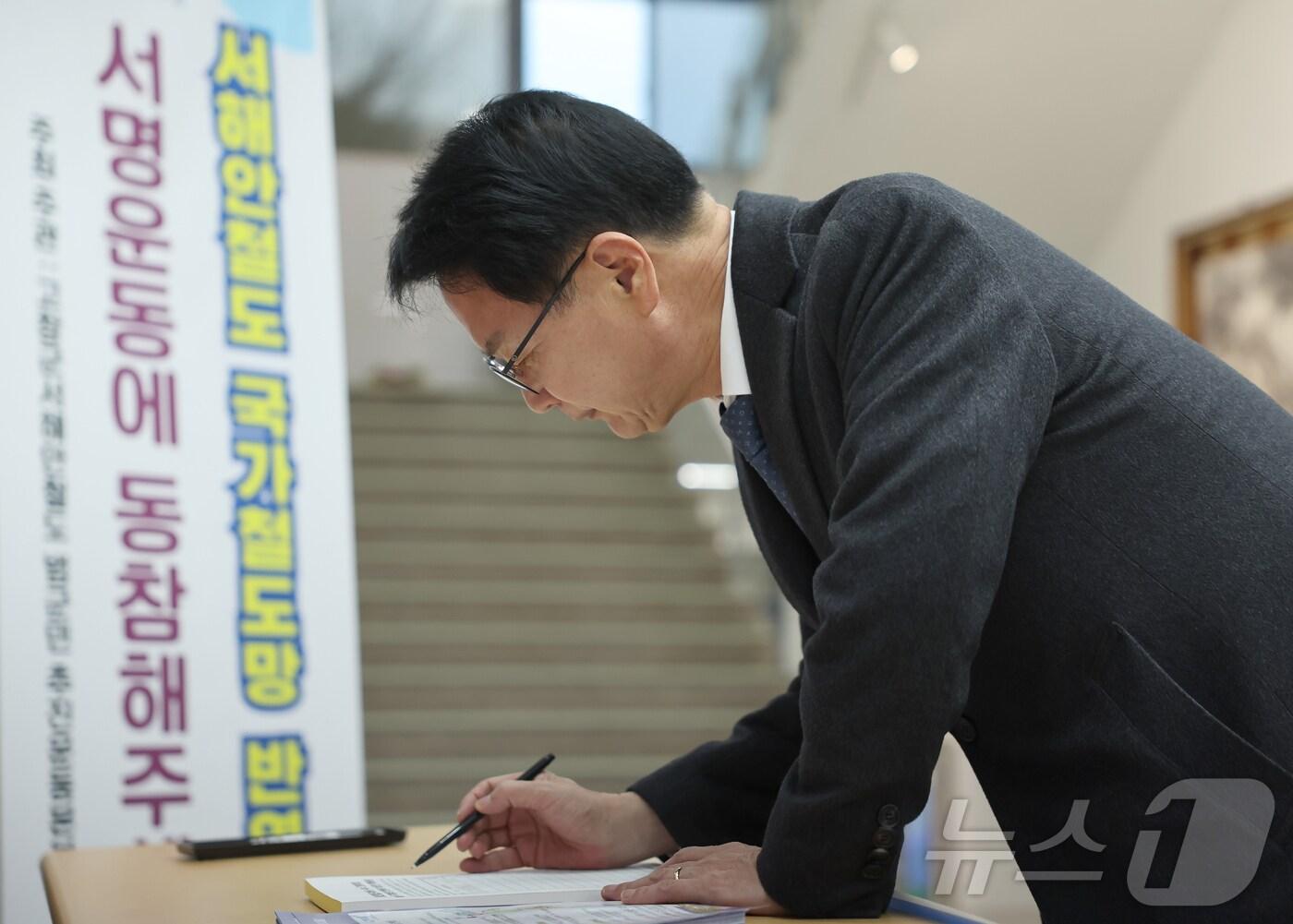 본문 이미지 - 심덕섭 전북자치도 고창군수가 9일 서해안철도 국가철도망 반영 촉구 서명운동에 참여하고 있다.&#40;고창군 제공&#41;2024.12.9/뉴스1