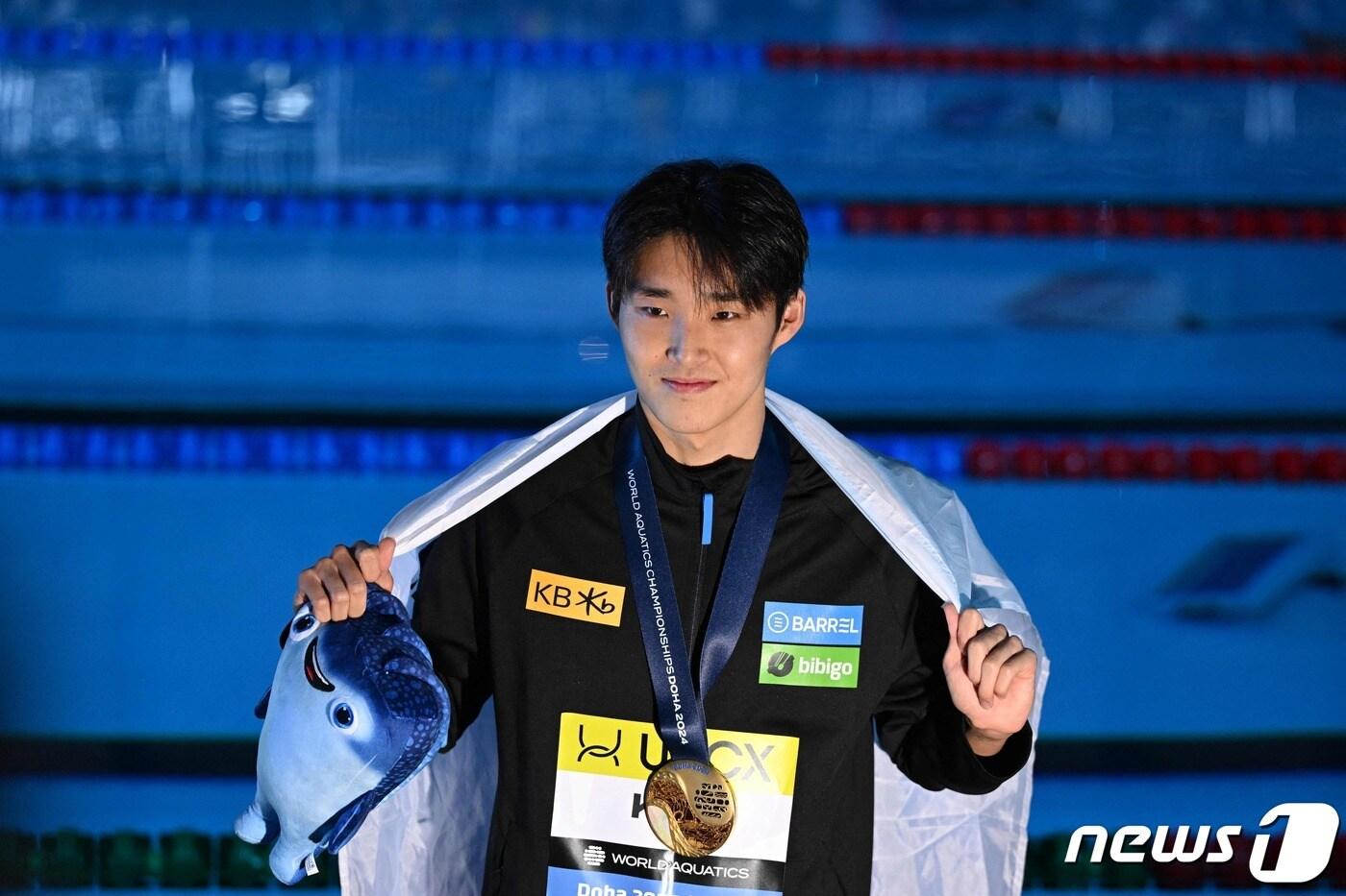 대한민국 수영 경영의 중장거리 간판 김우민(강원도청)이 12일(한국시간) 카타르 도하 어스파이어돔에서 열린 2024 국제수영연맹 세계선수권대회 경영 남자 자유형 400m 결승에서 우승한 뒤 금메달을 목에 걸고 기념 촬영을 하고 있다. ⓒ AFP=뉴스1 ⓒ News1 김진환 기자