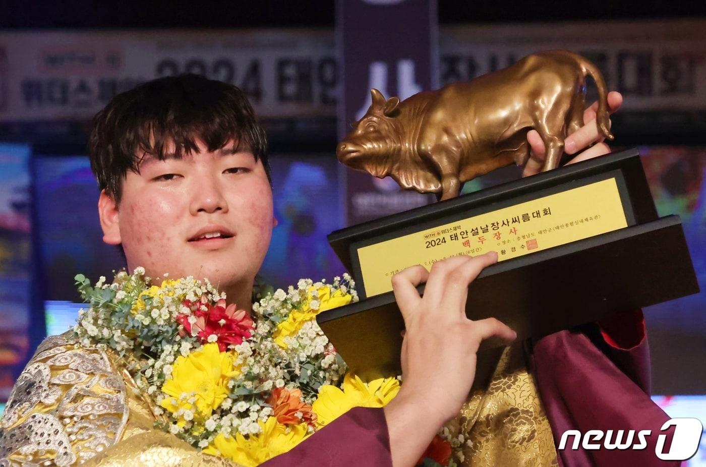 최성민이 12일 충청남도 태안군 태안종합실내체육관에서 열린 ‘위더스제약 2024 태안설날장사씨름대회’에서 백두장사(140kg이하)에 등극한 후 황소트로피를 들어 올리고 있다.(대한씨름협회 제공)