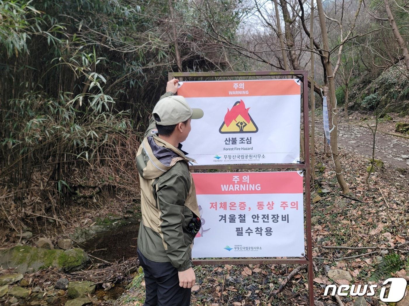 본문 이미지 - 13일 국립공원공단 무등산국립공원사무소 관계자가 탐방로 인근에 산불 조심 깃발을 게첩하고 있다. (공단 제공) 2024.2.13/뉴스1