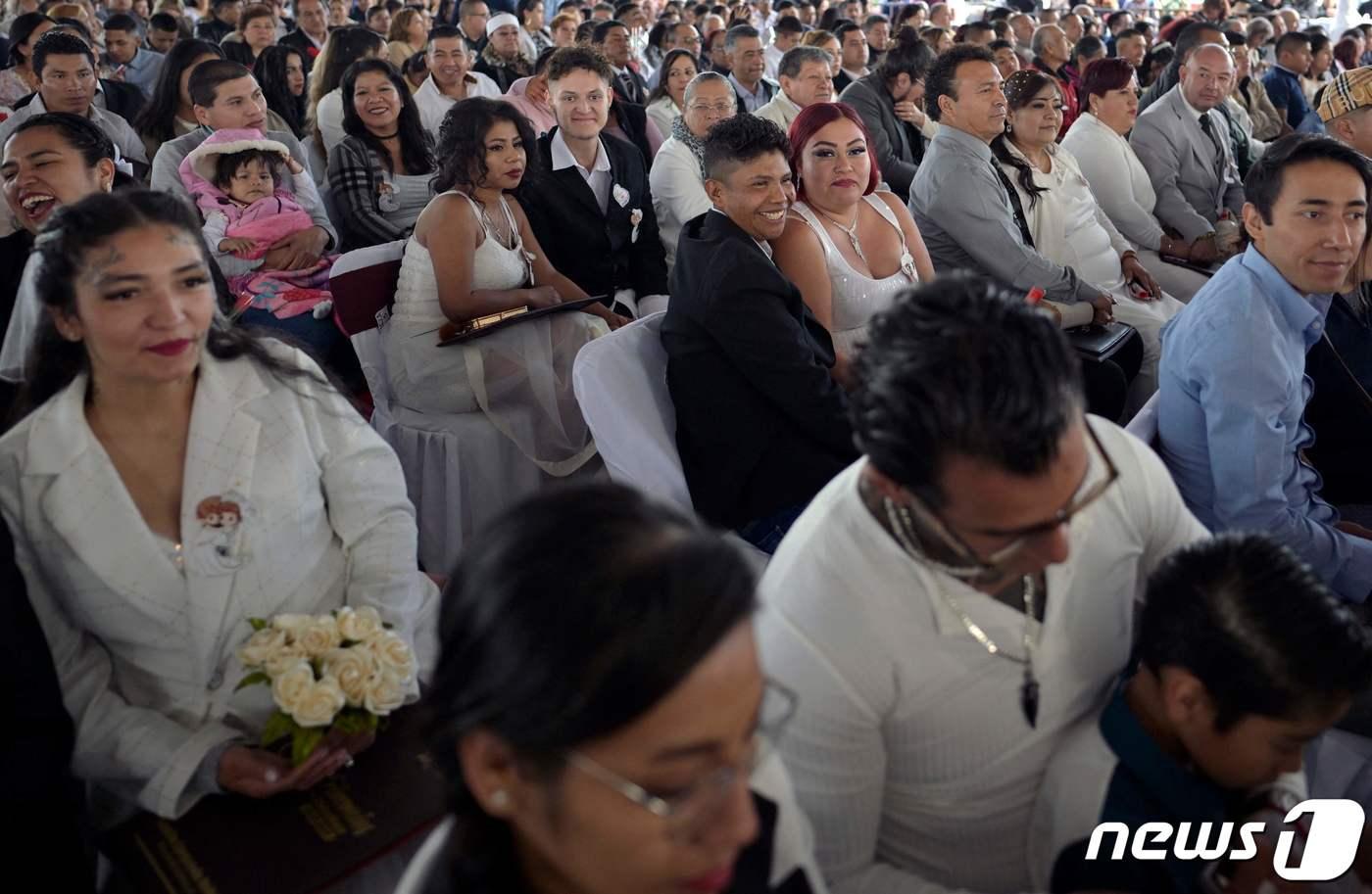 14일(현지시간) 멕시코의 멕시코시티 외곽 네사우알코요틀 마을에서 진행된 합동 결혼식에 부부들이 짝을 지어 행사에 참여하고 있다. 2024.02.14 ⓒ AFP=뉴스1 ⓒ News1 정지윤 기자