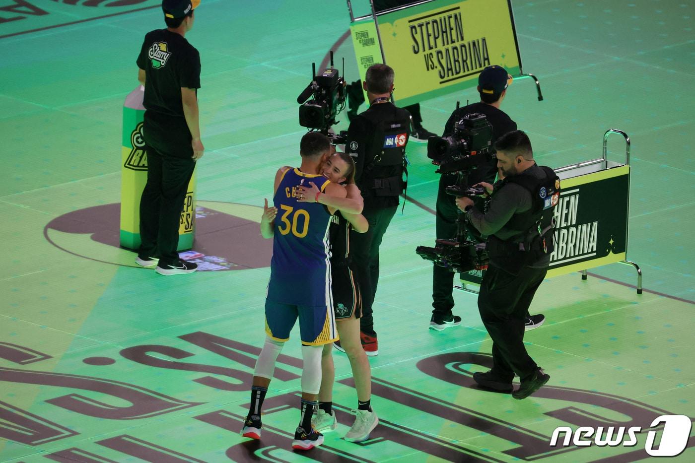스테픈 커리와 사브리나 이오네스쿠가 NBA 올스타전 전야제 특별 3점 콘테스트를 치른 뒤 포옹하고 있다. ⓒ 로이터=뉴스1 ⓒ News1 