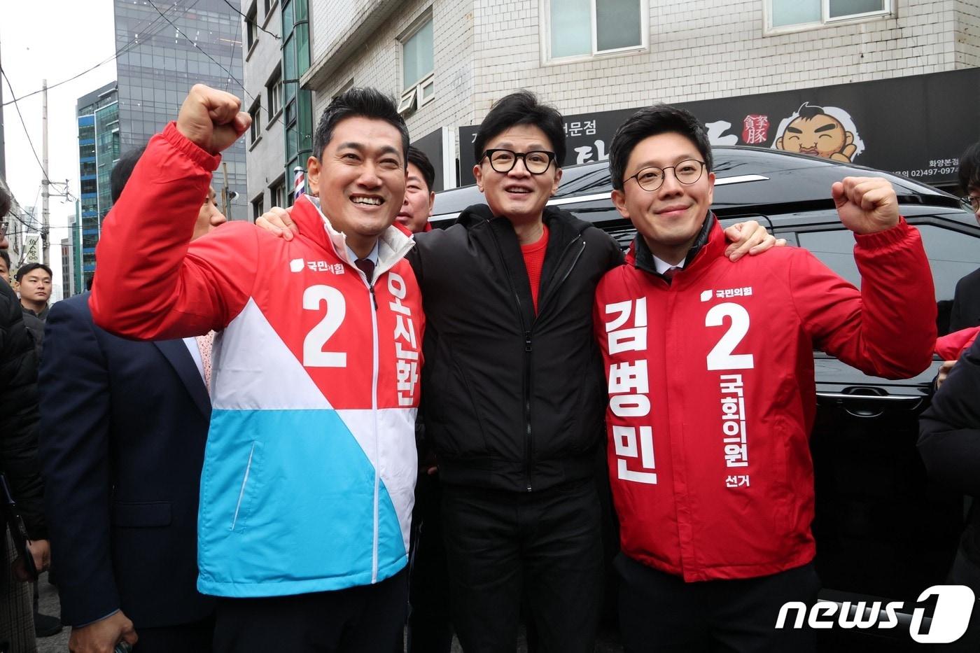 본문 이미지 - 한동훈 국민의힘 비상대책위원장이 20일 오후 서울 광진구 화양동에서 '시민이 안전한 대한민국' 현장 공약 발표를 하기 위해 이동하기 전 단수공천을 받은 오신환(왼쪽) 광진을 후보, 김병민 광진 갑 후보와 함께 손을 들고 있다. (공동취재) 2024.2.20/뉴스1 ⓒ News1 임세영 기자