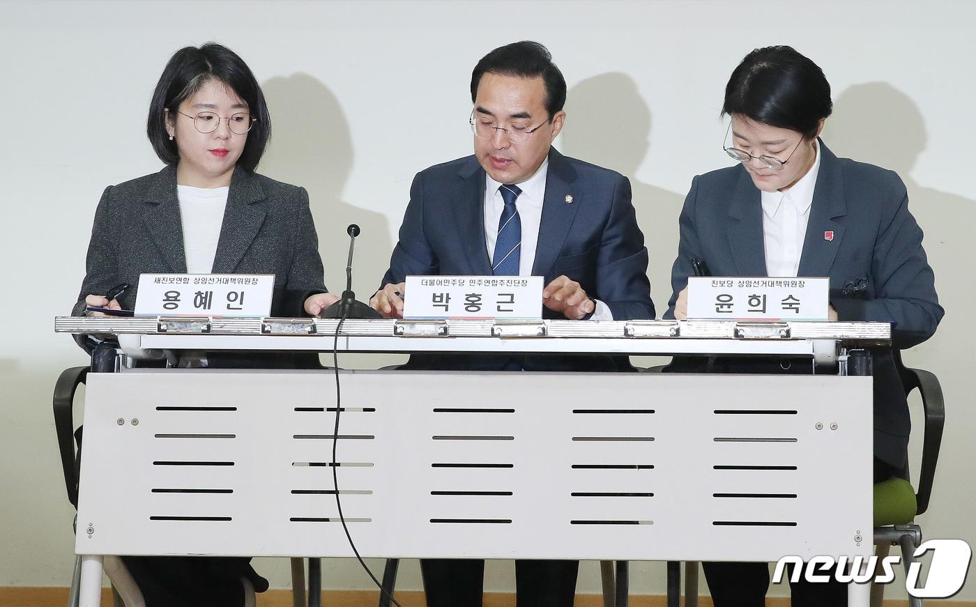 본문 이미지 - 2024년 2월 21일 용혜인 새진보연합 상임선대위원장(왼쪽부터), 박홍근 더불어민주당 민주연합추진단장, 윤희숙 진보당 상임선대위원장이 서울 여의도 국회 의원회관에서 열린 민주개혁진보 선거연합 합의 서명식에서 합의문에 서명을 하고 있다. 2024.2.21 ⓒ 뉴스1 임세영 기자