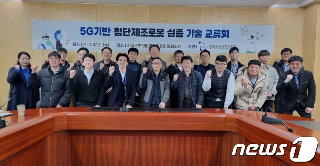 본문 이미지 - 21일 한국로봇산업진흥원에서 열린 '5G(5세대) 기반 첨단 제조로봇 실증 기술교류회'에 참가한 장비 구축기업 관계자들이 파이팅을 외치고 있다.(로봇산업진흥원 제공)