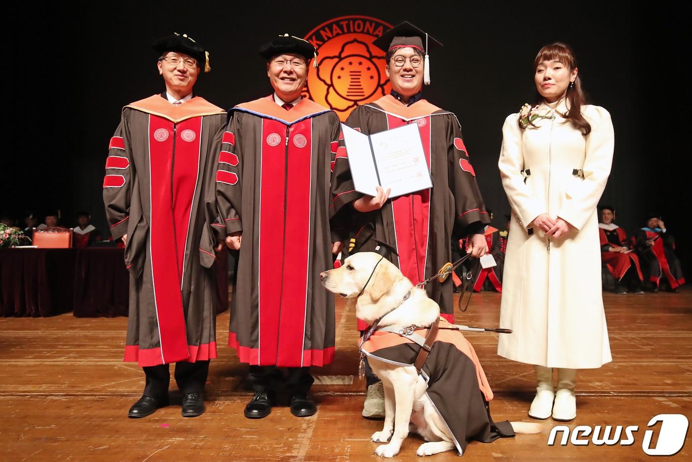 본문 이미지 -  대구 북구 경북대학교에서 지난 2월 열린 2024년 2월 학위수여식에서 서창교 경북대 대학원장(왼쪽)이 문헌정보학 석사 김경훈 씨, 안내견 래브라도 리트리버 '탱고', 홍원화 경북대 총장, 김예지 국회의원과 기념촬영을 하고 있다. /뉴스1 ⓒ News1 공정식 기자