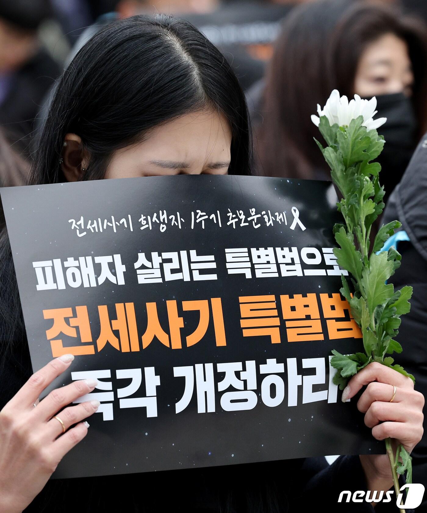 본문 이미지 - 전세사기 피해자가 24일 오후 서울 종로구 보신각 앞에서 열린 전세사기 희생자 1주기 추모문화제에서 희생자를 위한 국화꽃을 들고 있다. 2024.2.24/뉴스1 ⓒ News1 