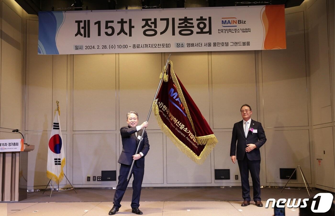 본문 이미지 - 김명진 제7대 메인비즈협회장이 당선 후 협회기를 힘차게 흔들고 있다.(메인비즈협회 제공)