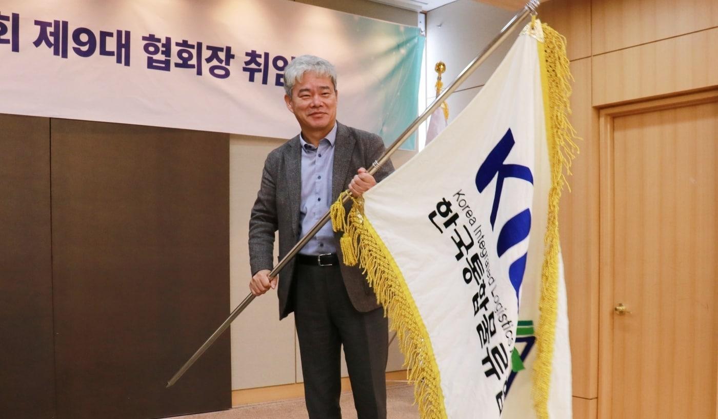 본문 이미지 - 한국통합물류협회 제9대 협회장 취임식에서 신영수 협회장이 협회기를 이양받아 흔들고 있다.(한국통합물류협회 제공) 